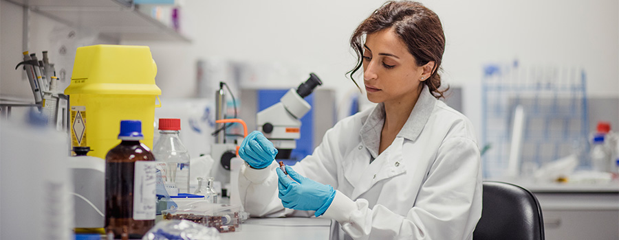 a lady in a lab coat performing a lab test