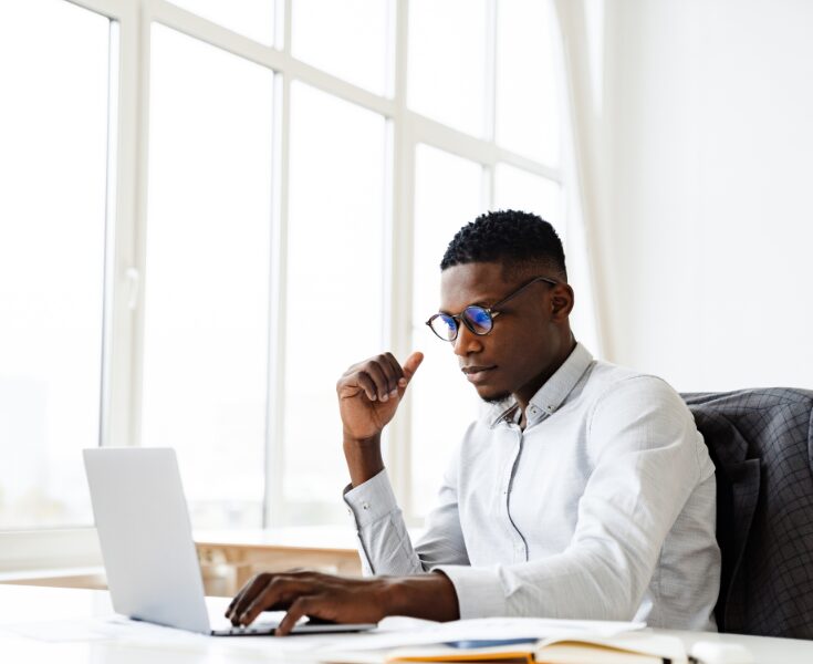 Professional working on a laptop, representing employee monitoring and workforce compliance tracking.